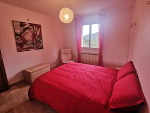 - une chambre avec un lit rouge et une fenêtre dans l'établissement La Villa de Luna, à Vals-les-Bains