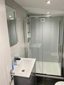 a white bathroom with a shower and a sink at Cullentra Lodge in Cushendall