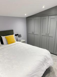 a bedroom with a large white bed with a yellow pillow at Cullentra Lodge in Cushendall