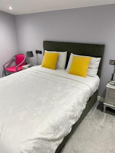 a bedroom with a large bed with two yellow pillows at Cullentra Lodge in Cushendall