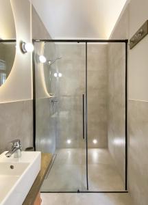 a glass shower in a bathroom with a sink at Domek Mrągowo in Mrągowo