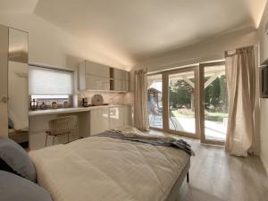 a bedroom with a bed and a kitchen with a window at Domek Mrągowo in Mrągowo