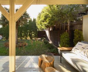 a patio with a couch and a table and a tree stump at Domek Mrągowo in Mrągowo