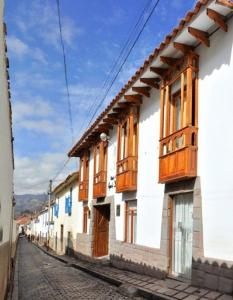 a row of buildings with wooden windows on a street at Awki´s Dream Hotel in Cusco