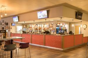 een restaurant met een bar met tafels en stoelen bij The Beaches - New Beach in Dymchurch