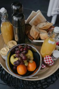 een dienblad met een schaal met fruit, brood en sap bij L'intimiste in Longeville-sur-Mer