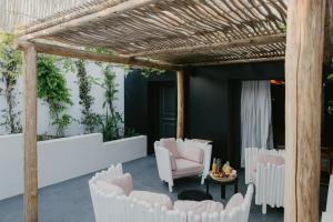 a patio with white chairs and a pergola at L'intimiste in Longeville-sur-Mer