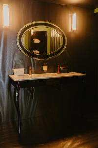 a bathroom with a sink and a mirror on a wall at L'intimiste in Longeville-sur-Mer