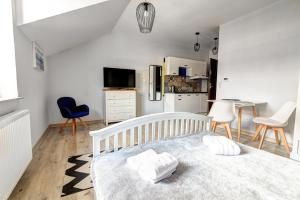 Il comprend une chambre blanche avec un lit et une cuisine. dans l'établissement Rentimi - Apartament Skandynawski 2, à Krynica-Zdrój