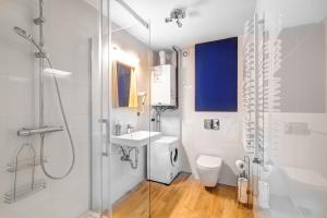 La salle de bains est pourvue d'une douche, de toilettes et d'un lavabo. dans l'établissement Rentimi - Apartament Skandynawski 2, à Krynica-Zdrój