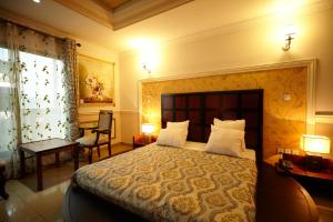 雅溫德的住宿－FELICIA HOTEL YAOUNDE，一间卧室配有一张大床、两盏灯和一把椅子