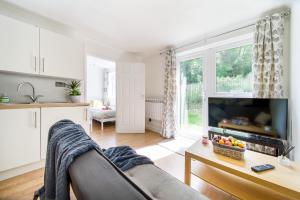 sala de estar con sofá y TV en 2 Bed Apt, FREE Parking, Long Stay Discount en Luton
