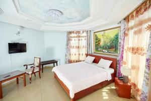 FELICIA HOTEL YAOUNDE في ياوندي: غرفة نوم بسرير وطاولة وتلفزيون