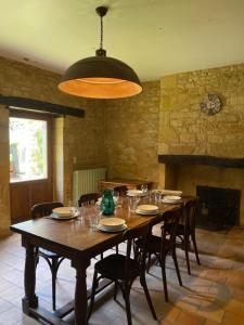 a dining room with a large wooden table and chairs at Les Courtines - Appartement de caractère à la Roque-Gageac - Les Chênes Verts in La Roque-Gageac +19 photos