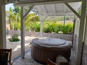 a large hot tub sitting under a pergola at Villa Fleur de Lys in Sainte-Anne