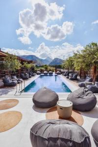 a hotel swimming pool with chairs and mountains in the background at Ikaros Suites in Amoudara Herakliou