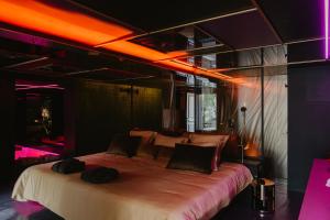 een slaapkamer met een groot bed met verlichting bij L'intimiste in Longeville-sur-Mer