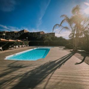a swimming pool in a yard with a palm tree at Hotel l'Isolella in Porticcio