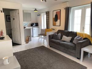a living room with a couch and a kitchen at The Shed in Merthyr Tydfil