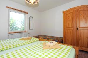 1 dormitorio con 2 camas y ventana en Pension Pradler Wohnung 1 en Carolinensiel