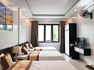 um quarto de hotel com duas camas e uma televisão em Đức Lan Hotel em Ha Giang