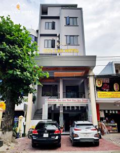 two cars parked in front of a building at Đức Lan Hotel in Ha Giang