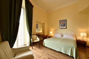 a hotel room with a bed and a chair at Hotel Europa & Concordia in Alassio