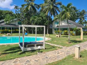 una piscina con un columpio y una casa en Hotel Villas Las Palmas al Mar, en Las Terrenas