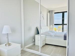 einen großen Spiegel in einem Schlafzimmer mit einem Bett in der Unterkunft Horyzont by Baltic Home in Misdroy