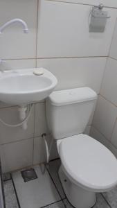 a bathroom with a white toilet and a sink at Sua Kitnet na Praia 12 Novinha Atenção Pequena Só prá dormir Ar Cond TV Microondas Frigobar Internet Rápida Não divide com ninguém Centro in Vila Velha