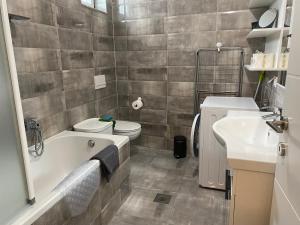 een badkamer met een bad, een toilet en een wastafel bij LEGA-LEGA in Osijek