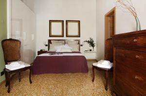 a bedroom with a bed with two chairs and a mirror at Residenza Roccamaggiore in Verona