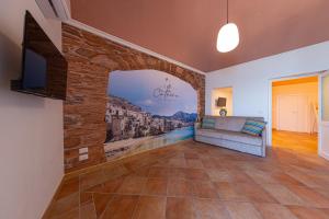 a living room with a couch and a tv at CATHENA HOLIDAY CEFALU in Cefalù