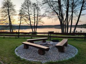 un parque con dos mesas de picnic y una hoguera en Siedlisko nr 4E i 4F nad jeziorem Skarlińskim, jezioro, mazury, domki letniskowe, bania en Kurzętnik