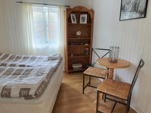 1 dormitorio con 1 cama, mesa y silla en Aline's Stue, B&B Utskarpen en Fuglstad