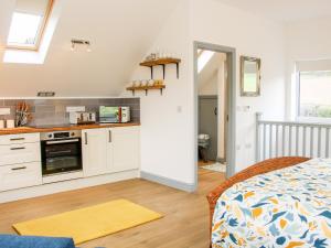 a kitchen with white cabinets and a bed in a room at Gerry's Place in Church Stretton