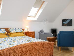 a bedroom with a bed and two chairs and a television at Gerry's Place in Church Stretton