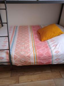 a bed with a yellow pillow on a bunk bed at Le Bain de mer, Studio à la plage, Pleneuf in Le Val-André