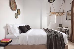 a bedroom with a bed with white sheets and pillows at Casa Bu in Fira
