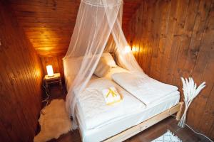 1 dormitorio con 1 cama con mosquitera en Beautiful Wooden House with Jacuzzi - Chalet Hisa Karlovsek, en Smarjeske Toplice