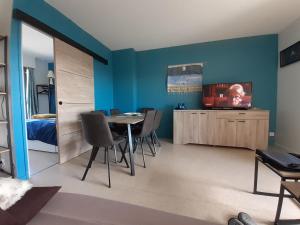 a dining room with a table and a tv at Lady Blue in Berck-sur-Mer