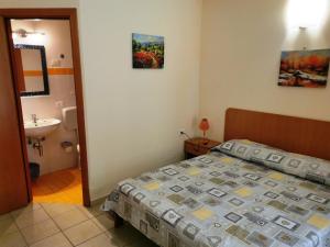 a bedroom with a bed and a bathroom with a sink at Bed & Breakfast Alba in Noto