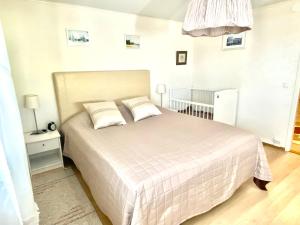 a bedroom with a white bed and a crib at Kuivaketveleen Piha in Lappeenranta