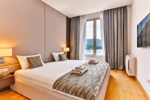 a hotel room with a large bed and a window at Victoria Apartments in Budva