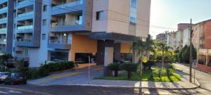 an apartment building with palm trees and a street at Veredas do Rio Quente 215 in Rio Quente