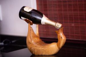 uma garrafa de vinho a ser derramada numa estátua de pato em Pecanwood Lake View em Hartbeespoort