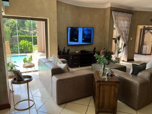 un soggiorno con divani e TV a schermo piatto di Pecanwood Lake View a Hartbeespoort