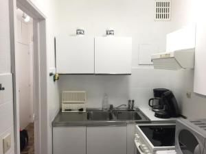 eine kleine Küche mit einer Spüle und einer Mikrowelle in der Unterkunft Wembley in Middelkerke