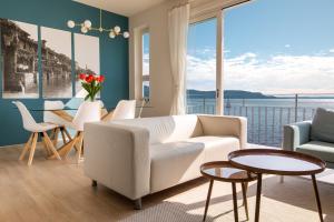 a living room with a white couch and a large window at Luxury Lake View Apartments in Salò