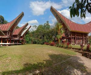 una casa con techo rojo y patio en Toraja Homestay & Coffee Bunna, en Rantepao